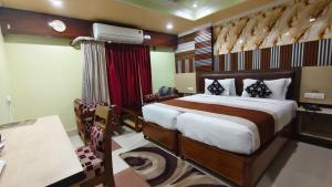a bedroom with a bed and a desk in a room at Hotel Gokul Plaza Near Railway Station Bhubaneswar in Bhubaneshwar