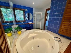 a large tub in a bathroom with blue tiles at BlueWater Penthouse Guest Suite 3 in Newport