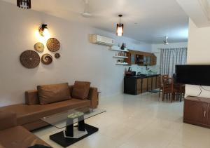 Villa Neesham Grande في بيناوليم: غرفة معيشة مع أريكة ومطبخ