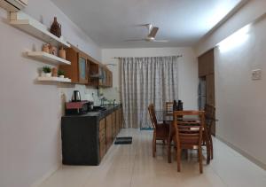 Villa Neesham Grande في بيناوليم: مطبخ وغرفة طعام مع طاولة وكراسي