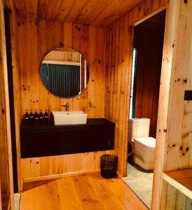 a bathroom with a sink and a mirror and a toilet at The Himalayan Phakding in Phakding