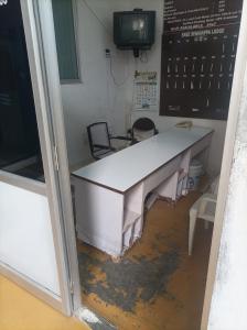 a large white desk in a room with a tv at chenniyappa lodge in Chennimalai