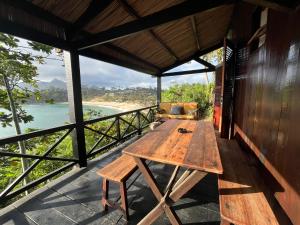 a wooden table on a balcony with a view of the ocean at Lavasoa in Tôlagnaro