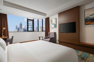 a hotel room with a bed and a flat screen tv at GME Taizhou Jingjiang City Bus Station Hotel in Jingjiang