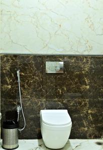 Kumar Green Resort في Jāmb: مرحاض أبيض في حمام به جدار من الرخام