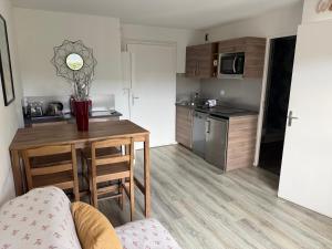 a small kitchen with a wooden table and a counter top at 2 PIECES JARDIN, ACCES DIRECT MER ET PROCHE THALASSO in Cabourg