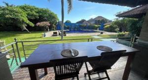 a wooden table and two chairs on a patio at Tulamben Wreck Divers Resort & Restaurant in Tulamben