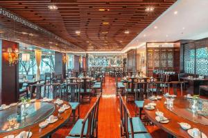 Un comedor con mesas y sillas en un restaurante. en Huangshan Shuguang Yusong Hotel, en Huangshan