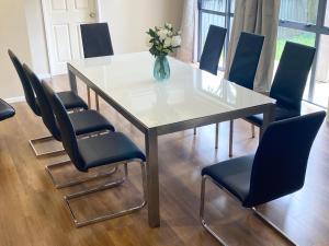 a dining room table with chairs and a vase of flowers at Kingsland Big Family Comfort House in Auckland