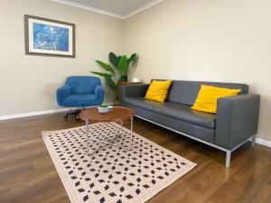 a living room with a couch and a blue chair at Kingsland Big Family Comfort House in Auckland