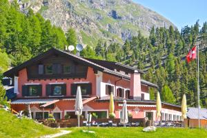 un edificio con ombrelloni e una montagna di Hotel Roseg-Gletscher a Pontresina