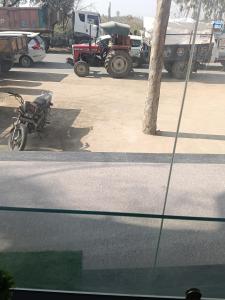 a motorcycle parked in a parking lot with trucks at Govardhan Seva Sadan govardhan in Govardhan