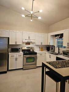 a kitchen with white cabinets and a stove top oven at Atlanta 3 Bedroom Home - by PriMary EVolution Properties in Atlanta