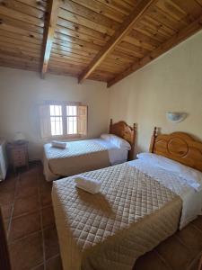 Un dormitorio con dos camas y techo de madera. en Los ferreles, en El Sabinar 30 fotos más