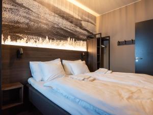 a bedroom with a large bed with white pillows at Stötens Stugor & Lägenheter in Stöten