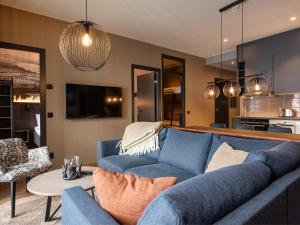 a living room with a blue couch and a table at Stötens Stugor & Lägenheter in Stöten