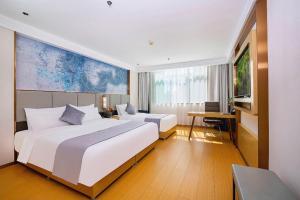 a hotel room with two beds and a television at GreenTree Inn Taiyuan PinGYAng Road Business Hotel in Taiyuan +266 photos