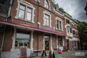 un bâtiment en briques avec un magasin dans une rue dans l'établissement Stone Station, à Esneux