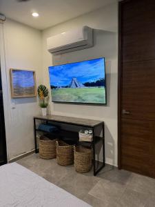 Habitación con TV en la pared y mesa. en Penca Suites Valladolid, en Valladolid