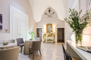 a living room with a table and chairs and a clock at B&B Centro Storico Lecce in Lecce