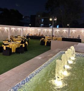 a restaurant with tables and chairs and a fountain at Studio by Jardin in Indore