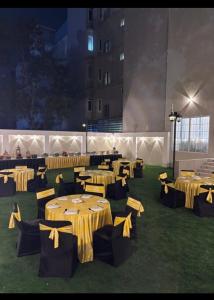 a room with tables with yellow bows on it at Studio by Jardin in Indore