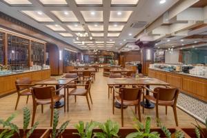 a restaurant with wooden tables and chairs and a bar at Hotel Pangeran in Pekanbaru