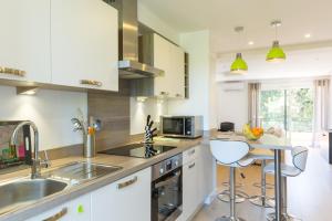 a kitchen with white cabinets and a sink and a counter at Résidence La Source in Toulon