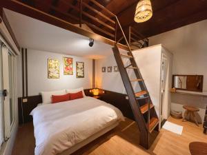 a bedroom with a loft bed with a ladder at 峇里島漫活民宿Bali Slow Homestay in Dongshan