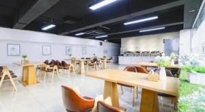 ein Zimmer mit Tischen und Stühlen in einem Restaurant in der Unterkunft Vatica HeFei Baishuiba BHG Hotel in Hefei