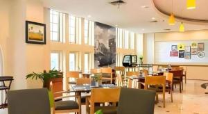 a dining room with tables and chairs in a restaurant at Hotel Horison Arcadia Heritage Surabaya in Surabaya