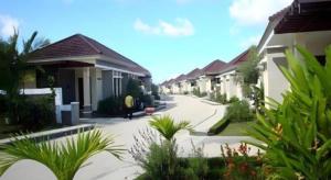eine Reihe von Häusern auf einer Straße mit Pflanzen in der Unterkunft The Luxio Hotel in Sorong