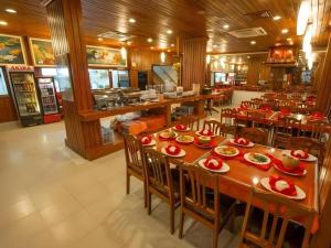 a restaurant with a long table with red dishes on it at Asia Hotel in Phnom Penh +171 photos