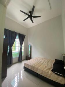 a bedroom with a bed and a ceiling fan at Banglo Jasin Perdana in Bemban