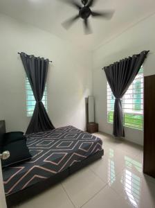 a bedroom with a bed and a ceiling fan at Banglo Jasin Perdana in Bemban