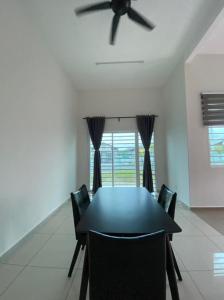 a dining room with a table and a ceiling fan at Banglo Jasin Perdana in Bemban