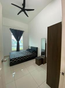 a bedroom with a bed and a ceiling fan at Banglo Jasin Perdana in Bemban