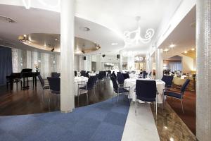 a dining room with white tables and chairs at Niebieski Art Hotel & Spa in Krakow
