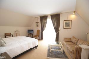 訥韋格利斯的住宿－瑞萊斯珀斯特酒店，一间卧室配有一张床和一张沙发