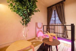 a room with two tables and a balcony with a tree at Tere Home Landed Stylish&Warm Flamingo Pinky House in Shah Alam