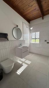 a bathroom with a toilet and a sink and a mirror at Kiepersol in Gansbaai +49 photos