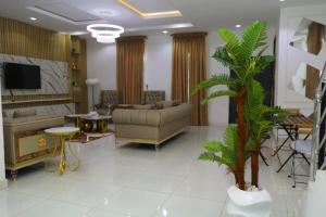 a living room with a couch and a palm tree at Luxury 4 bedroom fully detached duplex in Lekki