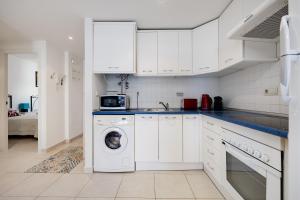 a white kitchen with a washing machine in it at CB Living - Apartment with roof terrace Aguamarina in Orihuela Costa