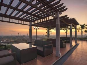 a rooftop patio with a pergola and a sunset at Star Hotel in Siantan