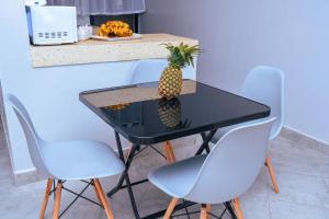 Havana Cottages-Hyrax Deluxe Master في ناكورو: طاولة عليها اناناس