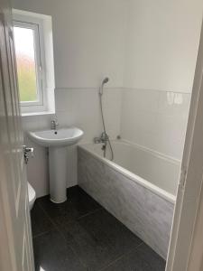 3 Bedroom Contractor house Glebe في ريتفورد: حمام مزود بمغسلة وحوض استحمام ومغسلة