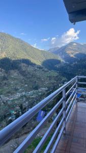 a balcony with a view of a mountain at Eleven 11 cafe and stay in Jibhi +17 photos