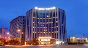 ein großes Gebäude mit Lichtern davor in der Unterkunft Jinjiang Metropolo Hotel - Taiyuan Economic Development Zone in Taiyuan