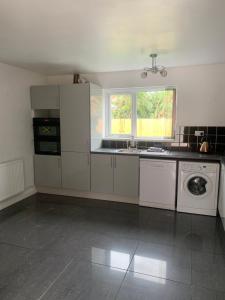 3 Bedroom Contractor house Glebe في ريتفورد: مطبخ أبيض مع حوض وغسالة أطباق