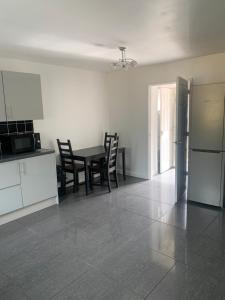 3 Bedroom Contractor house Glebe في ريتفورد: مطبخ وغرفة طعام مع طاولة وكراسي +صورتان